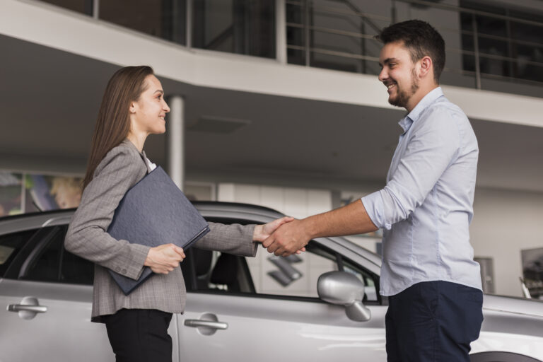 lateral view young man shaking hands with car dealer